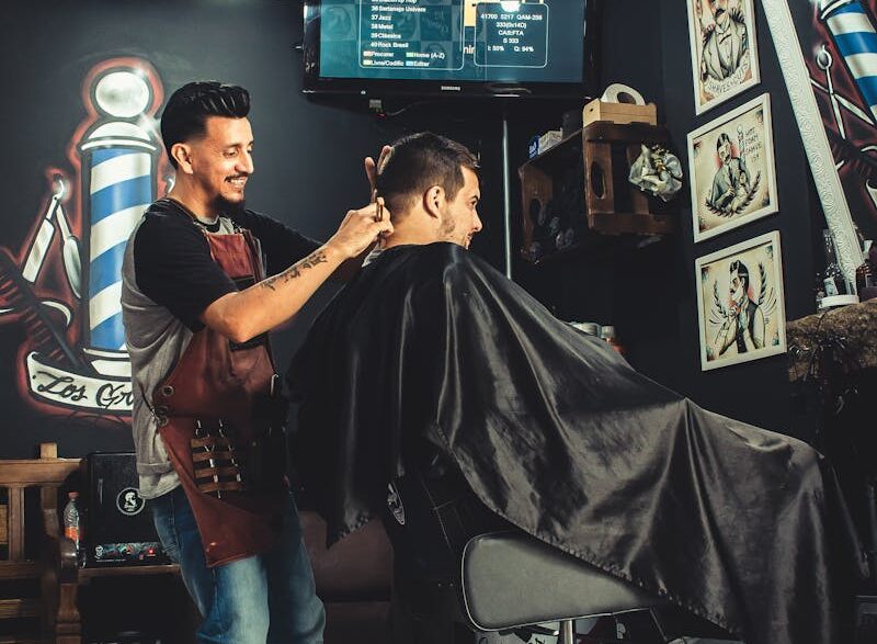 A barber skillfully cutting a man's hair in a trendy, well-decorated barbershop.