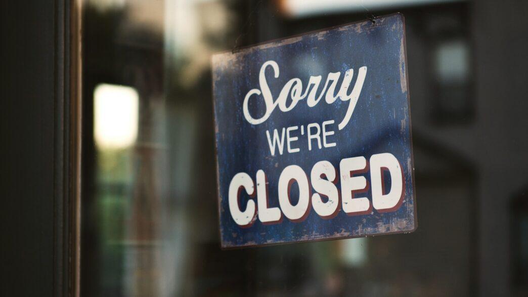 Sorry we're closed signage hanged on glass door
