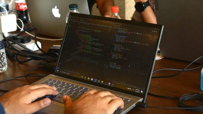 a man using a laptop computer on a wooden table
