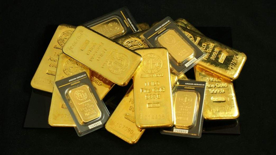 What Will the Next Gold Bust Look Like? 1 a pile of gold bars sitting on top of a table