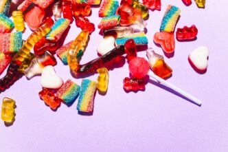 Lolli Enables Lightning Network Withdrawals 10 A vibrant mix of gummy candies and lollipops on a lilac background.