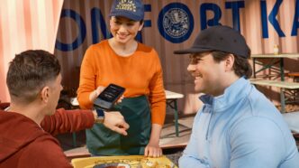 Customers pay using a smartwatch at a food truck.