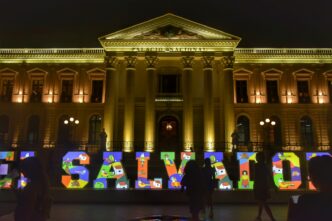 People standing in front of a building with a large sign