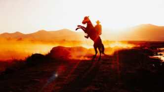 A cowboy on a rearing horse against a stunning sunset in rural Kayseri, Türkiye.