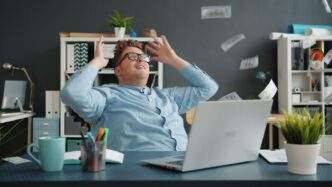 Man celebrating with money falling around him